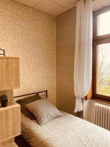 1 dormitorio con cama y ventana en LA MARIEFACTURE - Comme à la Bicyclette, en La Petite-Pierre