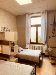 a bedroom with two beds and a window at LA MARIEFACTURE - Comme à la Bicyclette in La Petite-Pierre