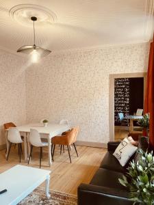 a living room with a white table and chairs at LA MARIEFACTURE - Comme un Livre Ouvert in La Petite-Pierre