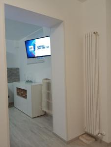 uma sala de estar com uma televisão e um radiador em pesa apartment B&B em Ascoli Piceno