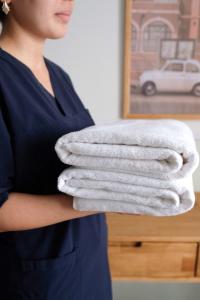 Kobieta trzyma stos ręczników. w obiekcie Meshk Airport Hotel w mieście Arnavutköy