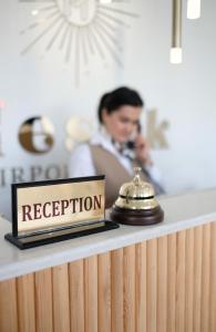 a reception sign sitting on top of a counter at Meshk Airport Hotel in Arnavutköy