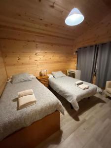 een slaapkamer met 2 bedden in een blokhut bij Las cabañas de Tino in Cimanes del Tejar