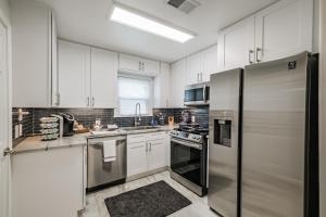 a kitchen with white cabinets and a stainless steel refrigerator at W 21st In The Heights, Pet Friendly, Walking in Houston