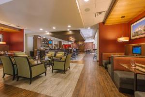 a restaurant with chairs and tables and a bar at Hotel MTK Mount Kisco in Mount Kisco