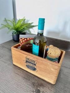 a wooden crate with a bottle of wine and a bear at Central Derby Urban 2 Bedroom Flat - An Oasis of Elegance! Free Parking and Wifi suitable for families and professionals in Derby