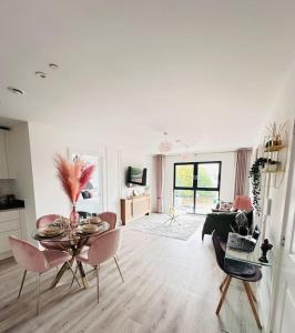 ein Wohnzimmer mit einem Tisch und rosa Stühlen in der Unterkunft Central Derby Urban 2 Bedroom Flat - An Oasis of Elegance! Free Parking and Wifi suitable for families and professionals in Derby