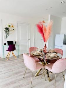 ein Esszimmer mit einem Tisch und rosa Stühlen in der Unterkunft Central Derby Urban 2 Bedroom Flat - An Oasis of Elegance! Free Parking and Wifi suitable for families and professionals in Derby