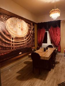 a dining room with a table and a large mural at LA MARIEFACTURE - Comme à l'Opéra in Neuf-Brisach +26 photos