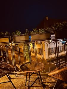 a group of chairs sitting on a balcony at night at LA MARIEFACTURE - Comme à l'Opéra in Neuf-Brisach