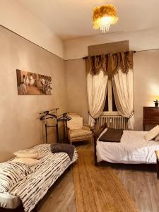 a bedroom with two beds and a window with a chandelier at LA MARIEFACTURE - Comme à l'Opéra in Neuf-Brisach