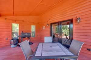 un patio con mesa, sillas y parrilla en Riverfront Arkansas Abode - Furnished Deck and Grill, en Mount Ida