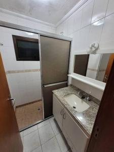 La salle de bains est pourvue d'un lavabo et d'un miroir. dans l'établissement Pérola de águas de Lindóia, à Águas de Lindóia