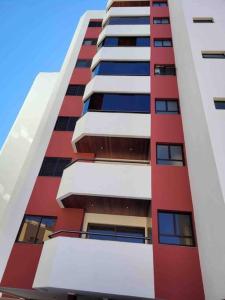wysoki budynek apartamentowy z czerwoną i białą kolorystyką w obiekcie Pérola de águas de Lindóia w mieście Águas de Lindóia