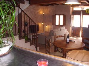 sala de estar con mesa y sofá en Casa Rural con Jacuzzi Taberna del Tio Pedro, en Cabañas de Polendos