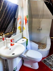 a bathroom with a white toilet and a sink at Villas Dora and Holly in Diani Beach