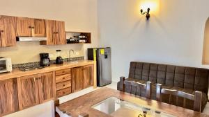 a kitchen with wooden cabinets and a stainless steel refrigerator at Casa Puerto Viejo in Puerto Escondido