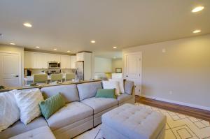 een woonkamer met een witte bank en een keuken bij Monroe Apartment Near Evergreen State Fairgrounds! in Monroe