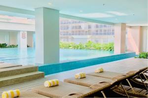 a pool with two chaise lounge chairs and a swimming pool at St. Honoré & St. Dominique in Iloilo City