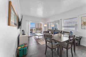 a dining room and living room with a table and chairs at Sandpiper Oceanfront 5F in Jacksonville Beach