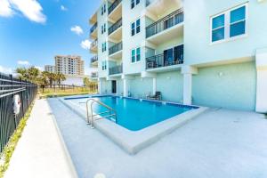 a swimming pool in front of a building at Sandpiper Oceanfront 5F in Jacksonville Beach