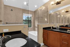 uma casa de banho com um lavatório, uma banheira e um chuveiro em 4BR. Disney World Vacation Townhome em Orlando
