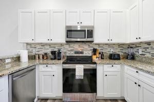 a kitchen with white cabinets and a stove top oven at 4BR Villa near Disney & Universal in Orlando, FL in Davenport