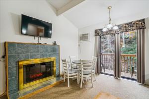 a dining room with a fireplace and a table and chairs at Cedarbrook Queen Suite 109 in Killington