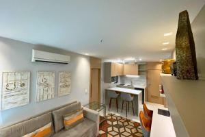 Una sala de estar con un sofá y una cocina. en Flat Ipanema com Garagem, en Río de Janeiro