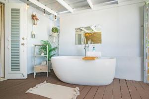 a bathroom with a white tub and a sink at Casa Loba Suite 1 with an outdoor tub in Rincon +22 photos