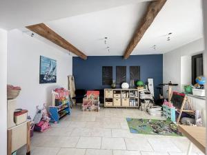 una sala de estar con paredes azules y una habitación llena de muebles. en Charme & cosy à Vourles, en Vourles
