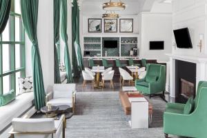 a restaurant with green chairs and tables and a fireplace at Courtyard by Marriott Stamford Downtown in Stamford