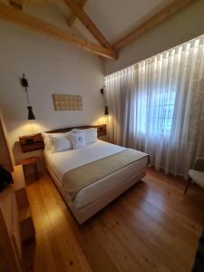 Un dormitorio con una gran cama blanca y una ventana en Porta Nobre - Exclusive Living Hotel, en Oporto