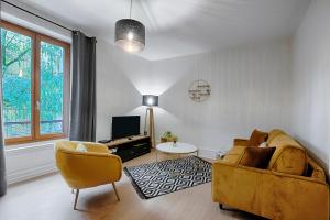 sala de estar con sofá y TV en Les Graveurs - Bourgoin-Jallieu - City Center, en Bourgoin