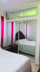 a bedroom with two beds and a mirror at Cómodo apartamento en Santiago in Licey al Medio