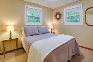 A bed or beds in a room at Roscommon Cottage - Walk to Higgins Lake!