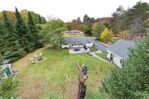 una vista aérea de una casa con patio en Roscommon Cottage - Walk to Higgins Lake!, en Roscommon