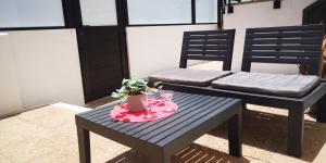 a blue bench with a table with glasses and flowers at Sunhouse in Playa Honda
