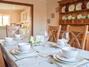 a dining room table with plates and wine glasses at Ty Twt in Llandissilio