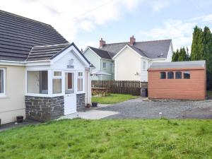 a row of houses in a yard with a garage at Ty Twt in Llandissilio