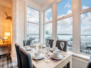 jadalnia ze stołem, krzesłami i oknami w obiekcie Argyle House w mieście Rothesay