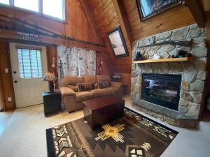 sala de estar con sofá y chimenea en U.P Norse A-frame close to Powderhorn Ski Resort, en Ironwood
