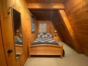 a bedroom with a bed in a wooden cabin at U.P Norse A-frame close to Powderhorn Ski Resort in Ironwood