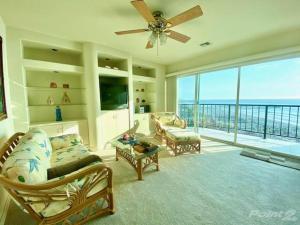 a living room with a ceiling fan and a view of the ocean at Oceana Casa Del Mar in Rosarito