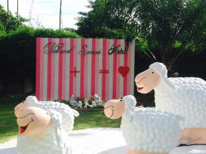 ein paar Schafe stehen vor einem Schild in der Unterkunft Natural Samui Hotel in Bophut 
