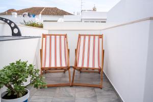 2 chaises assises sur un balcon dans l'établissement Tavira Nomad Guesthouse, à Tavira