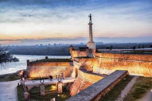 a statue on top of a wall next to a river at Unca in Belgrade
