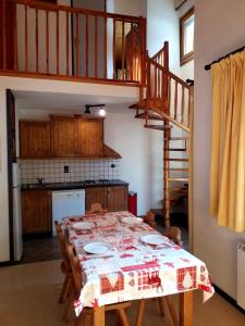 a dining room with a table and a kitchen at Le Napoléon in Lanslebourg-Mont-Cenis