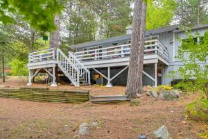 uma casa grande com um grande deque na floresta em Quiet Retreat on Lake with Kayaks, Boats and Bikes! em Wautoma