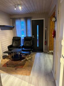 a living room with two chairs and a table at Very centrally located apartment with free parking in Tromsø
